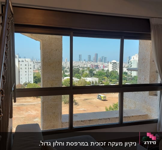 נוף עירוני מחלון עם וילון לבן